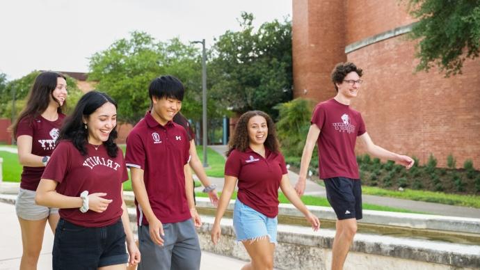 Group of student tour guides walk on Trinity campus
