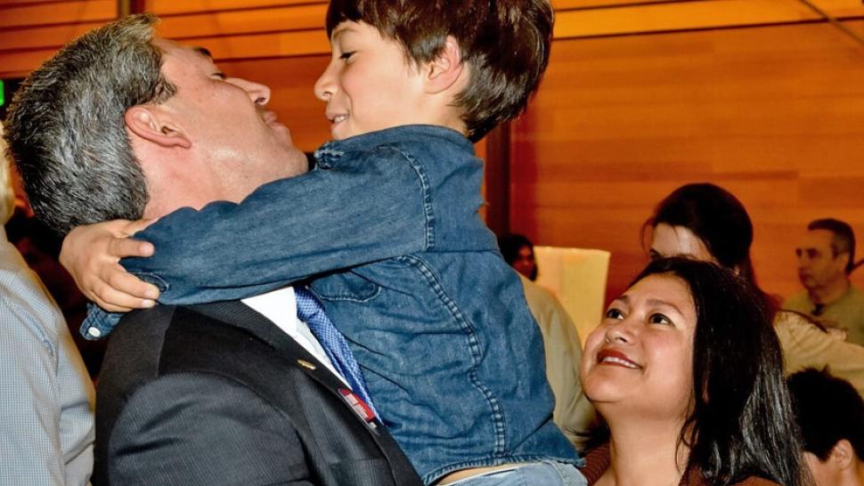 罗恩·尼伦伯格抱起他8岁的儿子乔纳